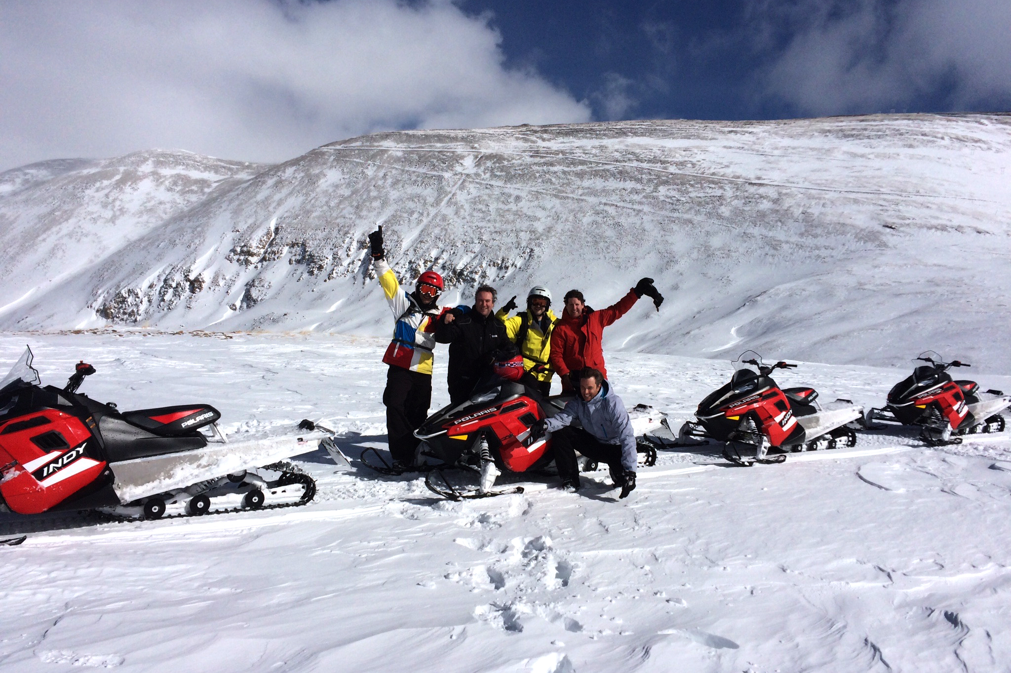 Group of snowmobilers with High Country Tours on a mountain ridge in Summit County